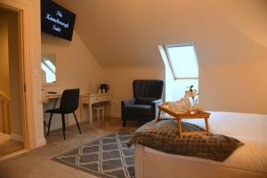 CastlereaにあるLisalway Country Lodgeのデスク、椅子、テーブルが備わる客室です。
