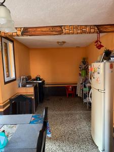 Homestay Mama Tuch في سان بيدرو لا لاغونا: مطبخ مع ثلاجة بيضاء في الغرفة