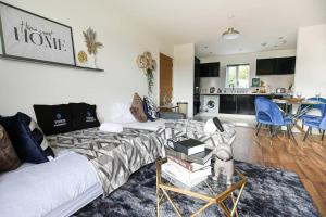 a living room with a bed and a kitchen at Luxury Apartment with Balcony, Fast WIFI, Smart TVs and Free Parking by Yoko Property in Milton Keynes