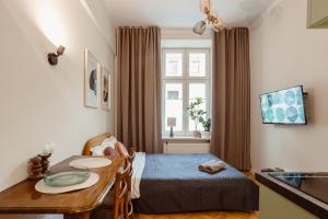 a small bedroom with a bed and a table at Apartament na Krakowskim Kazimierzu in Krakow