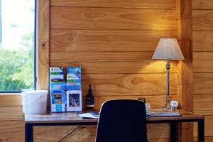 a wooden wall with a desk with a lamp and a chair at Deerbrooke Kaikōura Chalets - Chalet 2 in Kaikoura