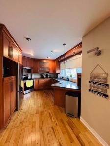 uma grande cozinha com pisos e armários de madeira em Family-Friendly 3BR Home with Backyard em Montreal