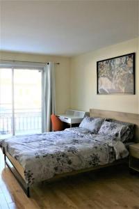 um quarto com uma cama, uma secretária e uma janela em Family-Friendly 3BR Home with Backyard em Montreal