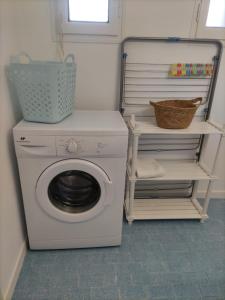 a laundry room with a washing machine and a shelf at Appartement Jas du Cassoir BRAS-D'ASSE in La Bégude-Blanche