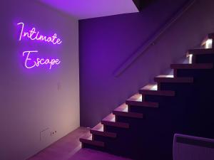 una escalera con una señal de neón en una habitación en Love room - Intimate Escape, en Arlon