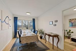 uma sala de jantar com uma mesa longa e cadeiras em Comfy 4-bedroom barnhouse Ideal for Long Stays em Åkersberga