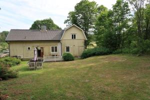 uma pequena casa num jardim relvado com um quintal em Comfy 4-bedroom barnhouse Ideal for Long Stays em Åkersberga