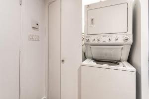un horno blanco con un espejo encima en Grand appartement 4 chambres - 335, en Montreal