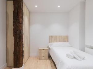 een slaapkamer met 2 bedden en een boom bij La cruz cozy apartment by Next Stop Bilbao in Bilbao