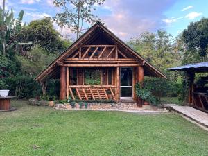 a log cabin with a grassy yard in front of it at Cabaña Manantial del Turpial in Jardin