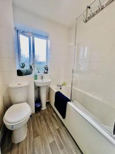 y baño con aseo, lavabo y ducha. en Brand New! The Cosy Cove by Artisan Stays I Free Parking I Weekly or Monthly Stay Offer I Sleeps 5, en Chelmsford