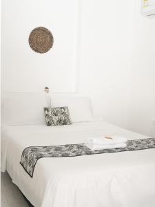 een wit bed met witte lakens en handdoeken erop bij ALOJAMIENTO MOON in Valledupar