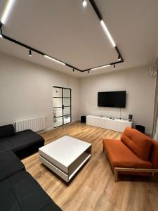 uma sala de estar com um sofá e uma televisão de ecrã plano em Love is... em Tbilisi
