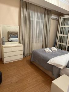 um quarto com uma cama, uma cómoda e um espelho em Love is... em Tbilisi