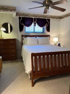 a bedroom with a large bed with a ceiling fan at Cozy, Pet-friendly Ligonier in Ligonier