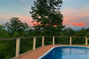a swimming pool on a deck with a fence at Mountain Top Oasis in Sevierville
