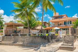 a house on the beach with palm trees at Paraíso de Tabuba - casa de aluguel por temporada - 32km de Maceió-AL - Pé na areia - 24h de Frente para o mar in Barra de Santo Antônio