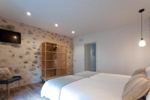 a bedroom with a white bed and a tv on a wall at La Casa de San Juan - DORAMAS in Telde