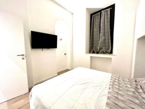a bedroom with a bed and a flat screen tv at Angelina's home - Milano Bovisa in Milan