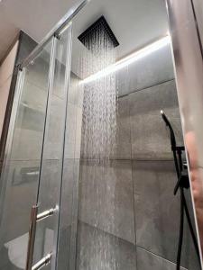 a shower with a glass door with a shower head at Angelina's home - Milano Bovisa in Milan
