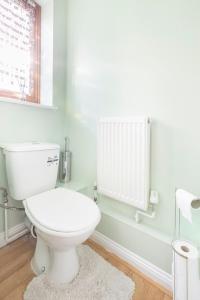 a bathroom with a white toilet and a window at Cozy Family-Friendly House (3mins from Erith and Slade Green station) in Erith