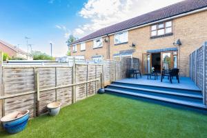 a backyard with a wooden fence and grass at Cozy Family-Friendly House (3mins from Erith and Slade Green station) in Erith
