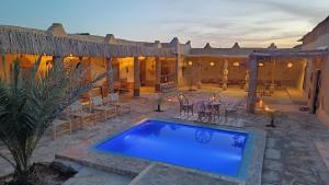 an outdoor patio with a blue swimming pool at kasbah luna del sur in Erfoud