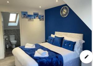 a blue bedroom with a large bed with blue pillows at The Westfield in Liversedge