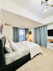 1 dormitorio con cama y ventana grande en LuxeBali Azure @ Azure North en San Fernando