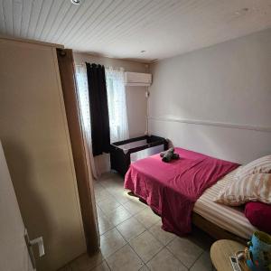 um quarto com uma cama com um cobertor rosa em LASYMPHO - Séjour de repos à la campagne em Le François