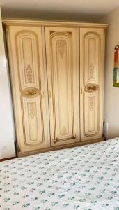 einen Holzschrank in einem Schlafzimmer mit einem Bett in der Unterkunft Appartement duplex in Asnières-sur-Seine