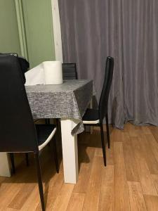 einem Esstisch mit 2 Stühlen und einem Tisch mit einer Kichererbse in der Unterkunft Appartement duplex in Asnières-sur-Seine