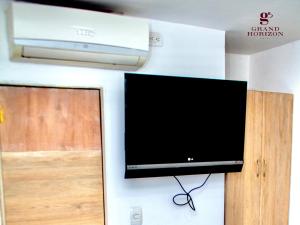 uma televisão de ecrã plano pendurada numa parede em Hotel Grand Horizon Rodadero em Santa Marta
