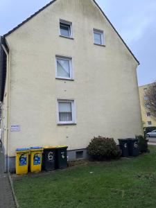 a house with four trash cans in front of it at Red Dot Apartments in Kamen