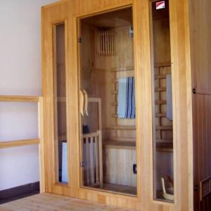 d'une armoire en bois avec des portes en verre. dans l'établissement Gyümölcsliget Vendégház, à Csehimindszent