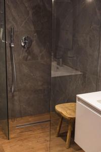 a shower with a glass door and a stool in a bathroom at Lovely 3 bed - Apartment -Sliema in Sliema