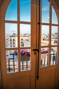 a door with two windows and a view of a city at Lovely 3 bed - Apartment -Sliema in Sliema