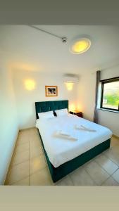 um quarto com uma cama grande e uma janela em Portimao Central Holiday Guesthouse em Portimão