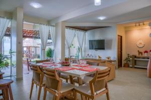 a dining room with a table and chairs and a kitchen at Paraíso de Tabuba - casa de aluguel por temporada - 32km de Maceió-AL - Pé na areia - 24h de Frente para o mar in Barra de Santo Antônio