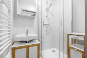 ein weißes Badezimmer mit Waschbecken und Dusche in der Unterkunft 2 bedrooms apartment near the metro in Prag