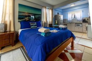 a blue bedroom with a large bed with blue sheets at Beach Studio in Crown Point in Bon Accord