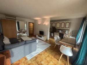 a living room with a couch and a table at F2 avec Terrasse, Parking gratuit in Guyancourt