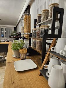 a table with shelves filled with pots and mugs at Hotel Fuchs & Hase SELF CHECK IN in Rosegg