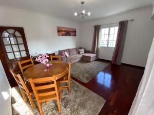 uma sala de estar com uma mesa e cadeiras e um sofá em Santa Luzia Apartment no Funchal