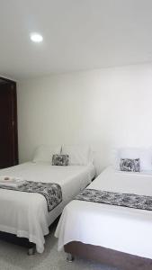 twee bedden naast elkaar in een kamer bij ALOJAMIENTO MOON in Valledupar