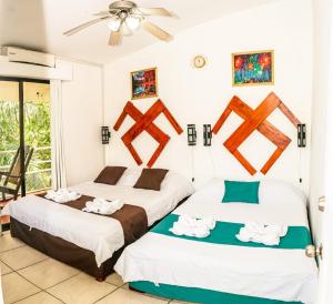 a bedroom with two beds with towels on them at Manuel Antonio Inn Paradise in Quepos