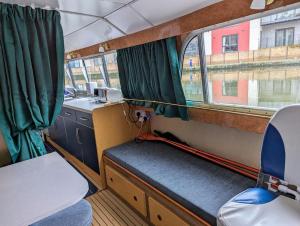 a small train room with a bench and a window at Unique Boat in Chelmsford city in Chelmsford