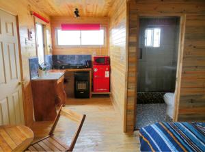 a small kitchen with a red stove and a sink at Lilafken Apart Pichilemu in Pichilemu