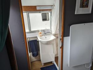 a small bathroom with a sink and a window at Unique Boat in Chelmsford city in Chelmsford