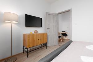 a bedroom with a tv on the wall and a dresser at 2 bedrooms apartment with kitchen near the subway in Prague